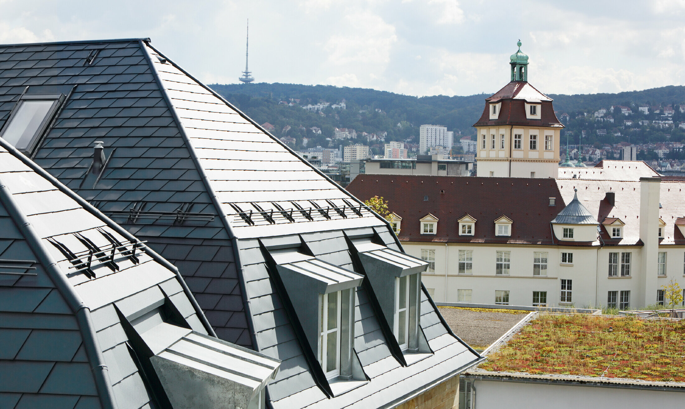 Altes Stadthaus in Stuttgart mit geknicktem Dach und vielen Gaubenfenstern, eingedeckt mit der Aluschindel von PREFA in P.10 Anthrazit