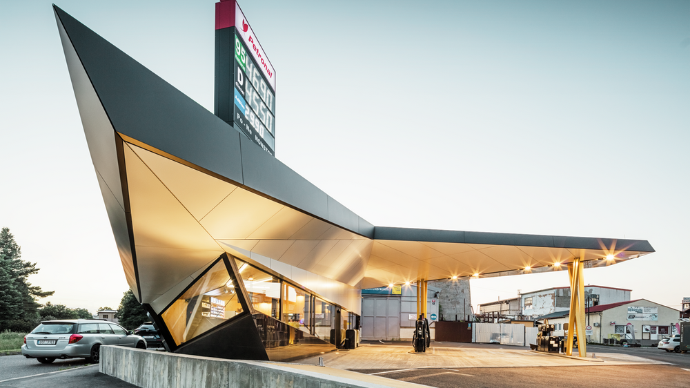 Seitlicher Blick auf die dynamische, mit Aluminium bekleidete Tankstelle von Architekt Daniel Zerzán: Etliche Dreiecke und Trapeze strukturieren die Fassade.