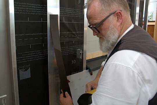 Thomas Weiß bringt das selbstklebende EPDM-Fugenband vor dem Befestigen der Platten auf eine Alu-Unterkonstruktion an.