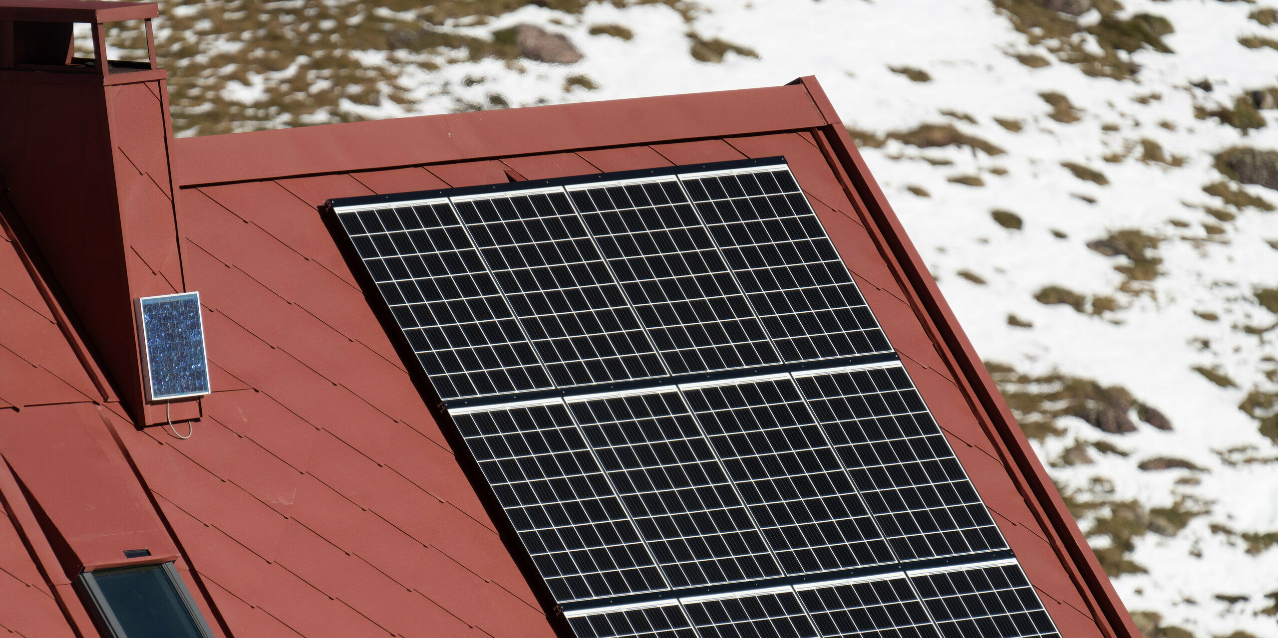 Vogelperspektive auf Schutzhütte Arlet im Pyrenäen-Nationalpark mit PV-Anlage und PREFA Dachrauten 44x44 in P.10 Oxydrot am Dach