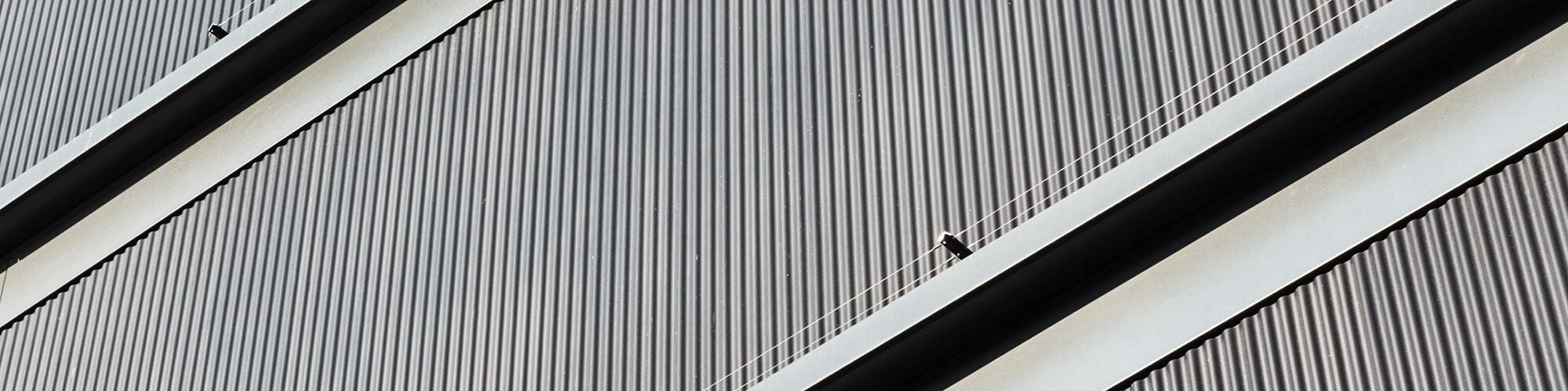  Ein Detail der geradlinigen, schwarzgrauen Aluminiumfassade, die der verwendeten vorvergrauten Weißtanne zum Verwechseln ähnlich aussieht.