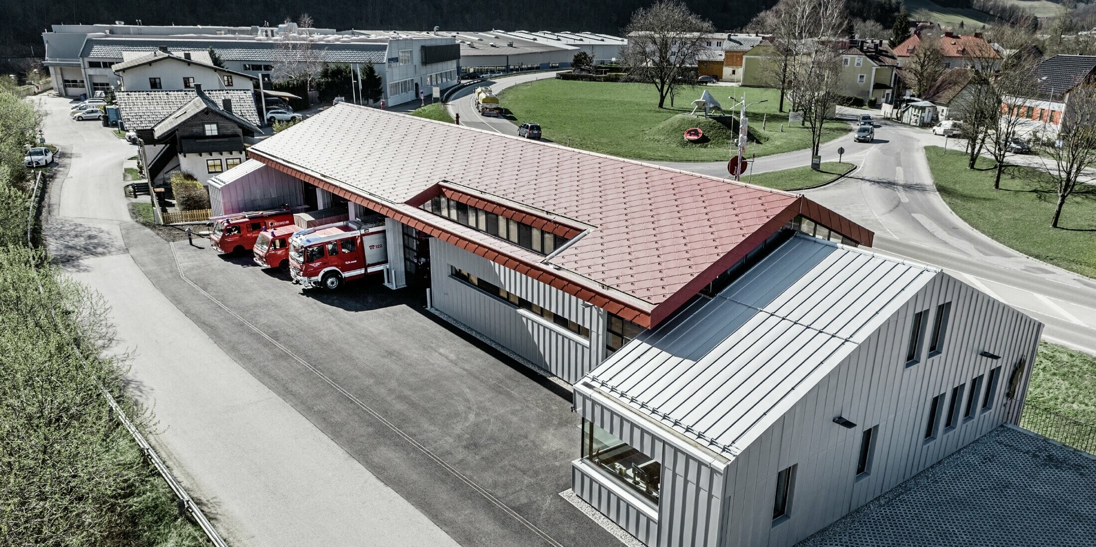 Aufnahme der Betriebsfeuerwehr in Marktl/Lilienfeld in der Vogelperspektive. Der linke Gebäudeteil wurde komplett am Dach und der Fassade mit der raute 44 in Oxydrot verkleidet. Der rechte Teil bekommt eine Aluminiumhülle mit Prefalz in Silbermetallic.