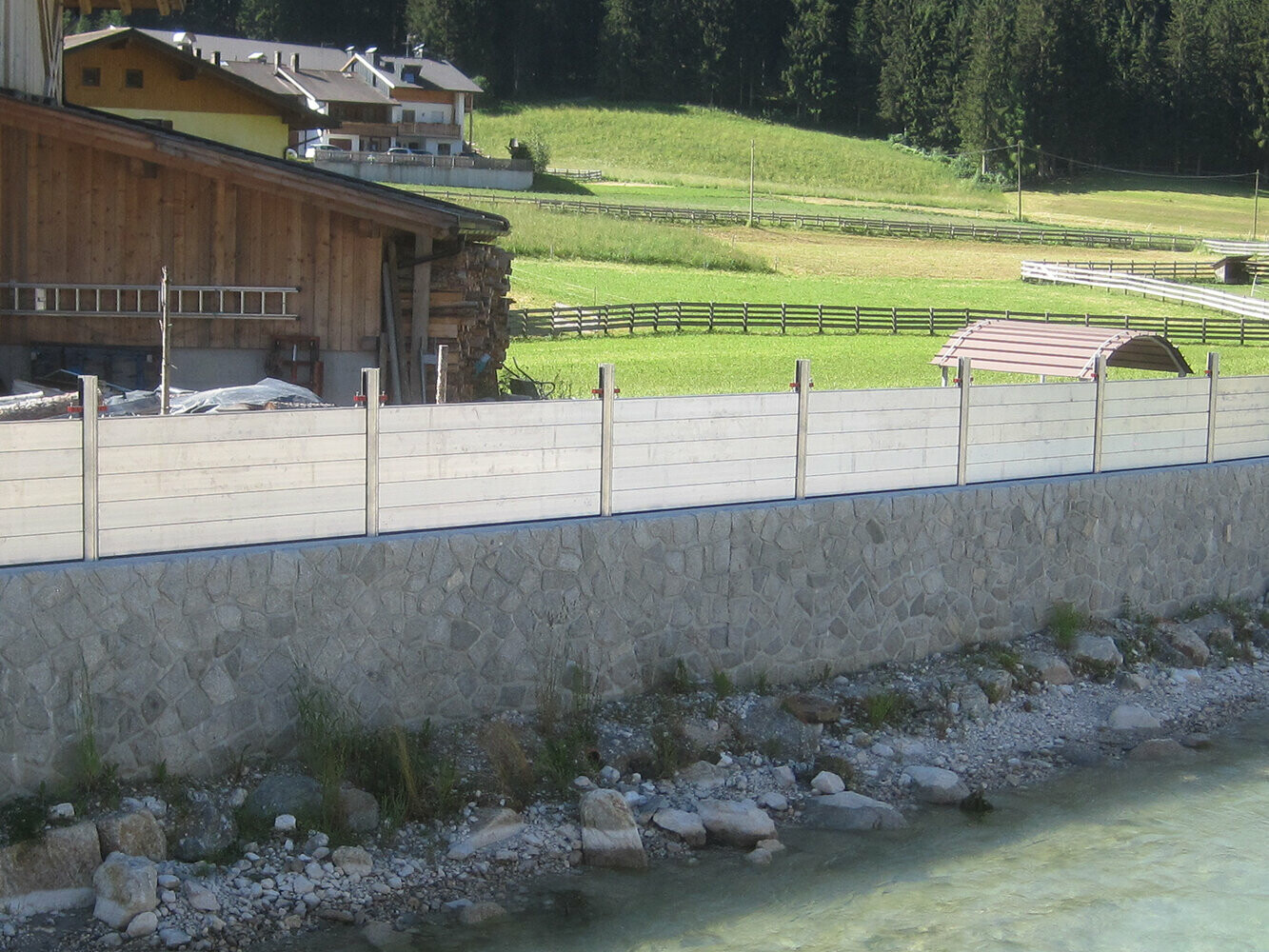 Hochwasserschutzsystem von PREFA als Schutz vor einem vorbeifließenden Bach