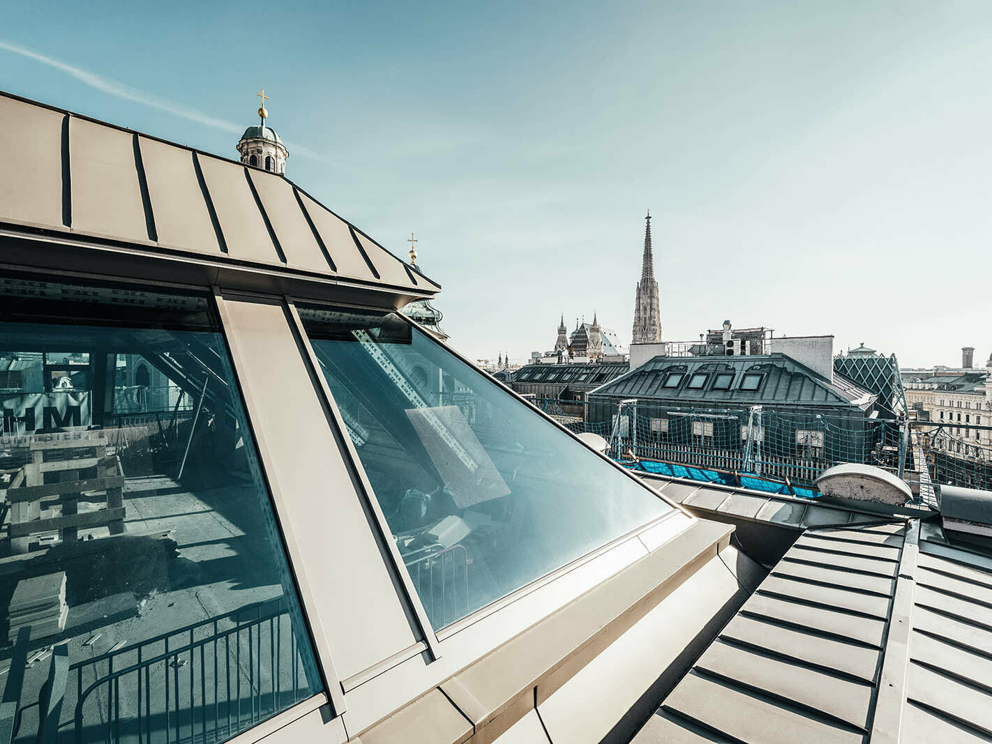 Im Vordergrund ist der Dachausbau des Gebäudes zu sehen, mit Blick auf den Stephansdom in Wien, der im Hintergrund zu sehen ist.