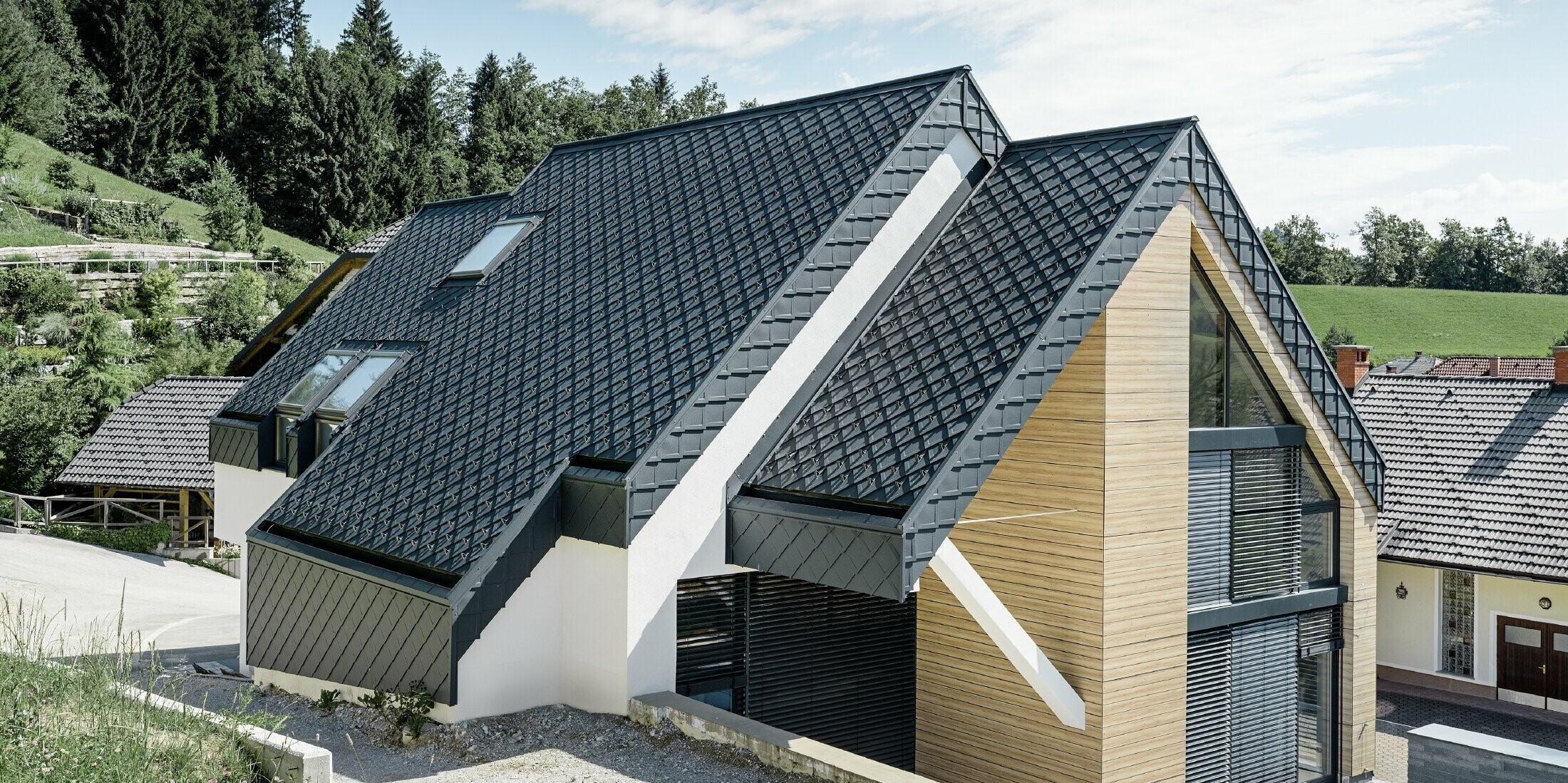 Einfamilienhaus mit Satteldach ohne Dachvorsprung mit einer Fassade in Holzoptik und einem Aluminiumdach in anthrazit