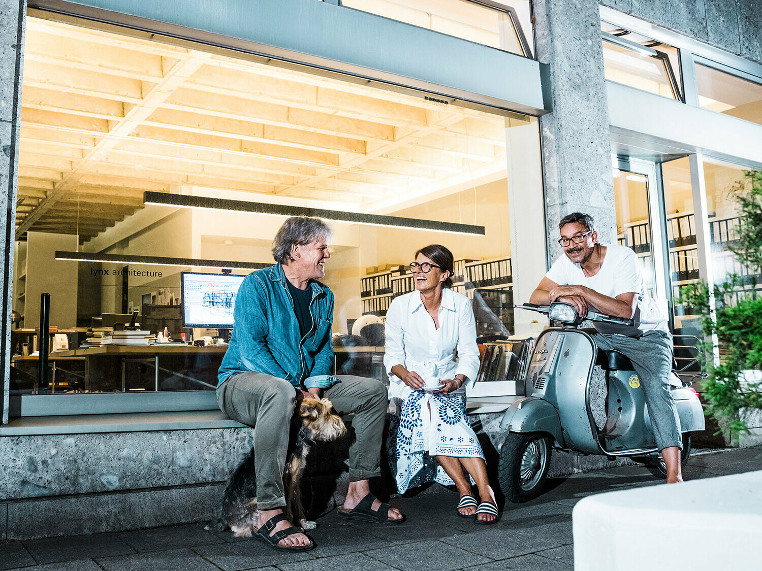 Portrait der Architekten Volker Petereit, Susanne Muhr und Dirk Härle mit Hund Emma vor ihrem Büro in München.