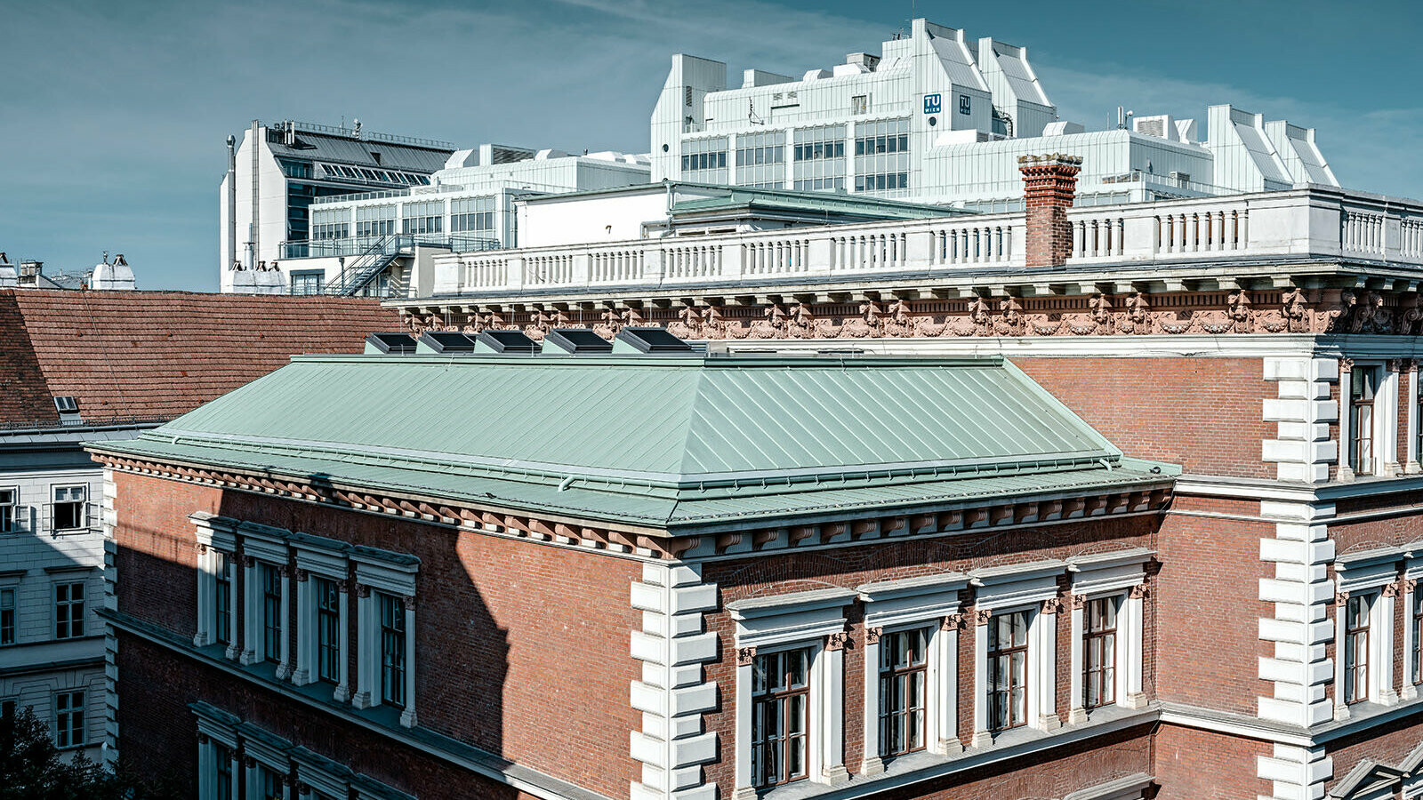 Eine Detailansicht des Dachsystem Prefalz von PREFA in der Farbe Opalgrün der Evangelischen Volkschule am Wiener Karlsplatz.