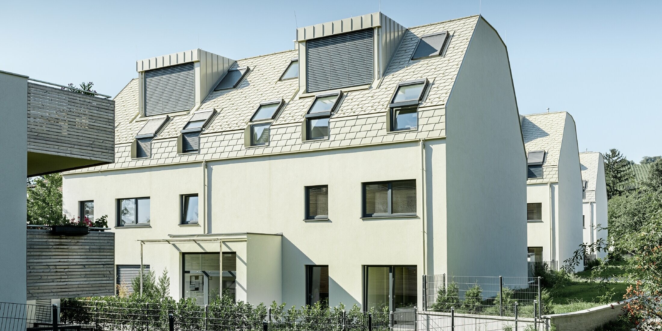 neue Wohnhausanlage mit großer Aluminium Dachfläche und vielen Dachflächenfenstern 