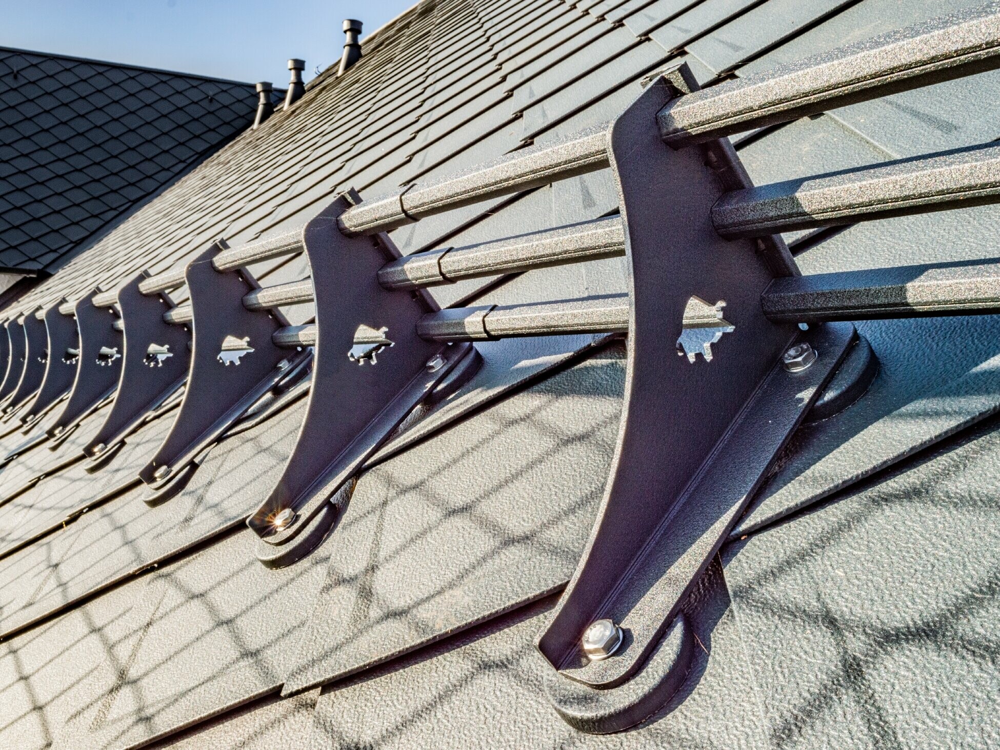 Detailaufnahme des PREFA Schneerechensystems auf der PREFA Dachraute 29 × 29 in Anthrazit auf dem Hotel Burg Maienluft.