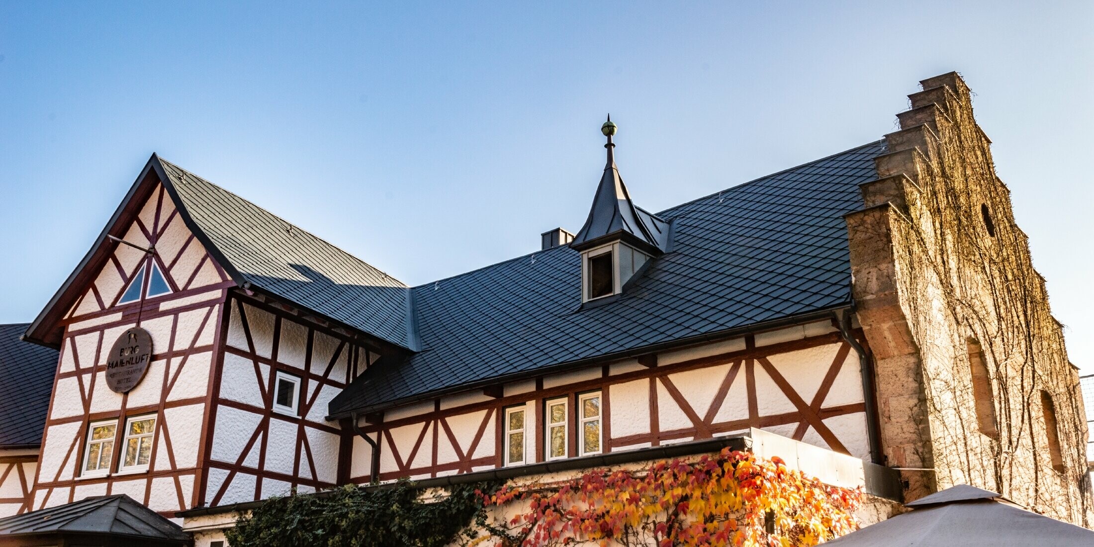 Das Hotel Burg Maienluft wurde mit der PREFA Dachraute 29 × 29 in Anthrazit neu eingedeckt, die Fassade ist eine Fachwerk-Fassade.