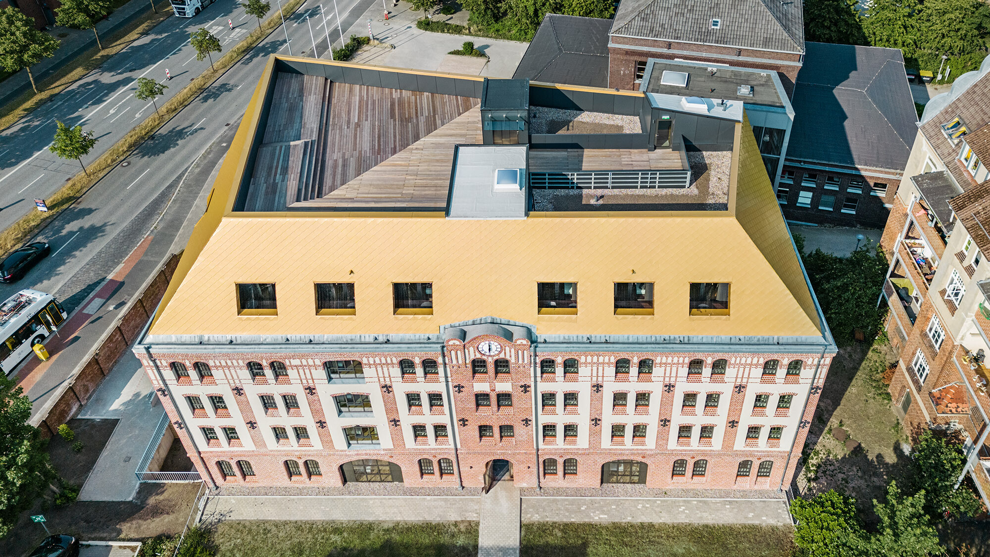 Der Bau aus der Vogelperspektive, zu sehen sind die Dachterrasse, das neue Dach sowie die historische Fassade und die gebaute Umgebung.