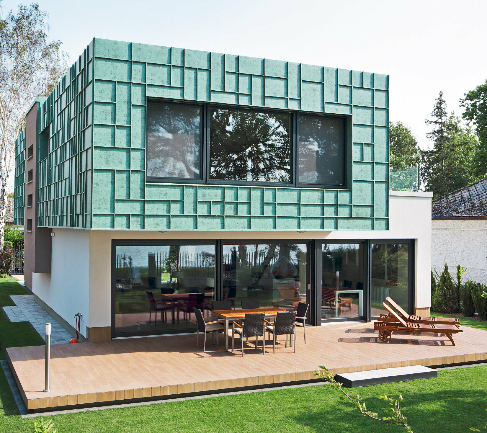 Modernes Einfamilienhaus mit sturmsicherer Fassade, die mit PREFALZ in P.10 Patina Grün verkleidet wurde.