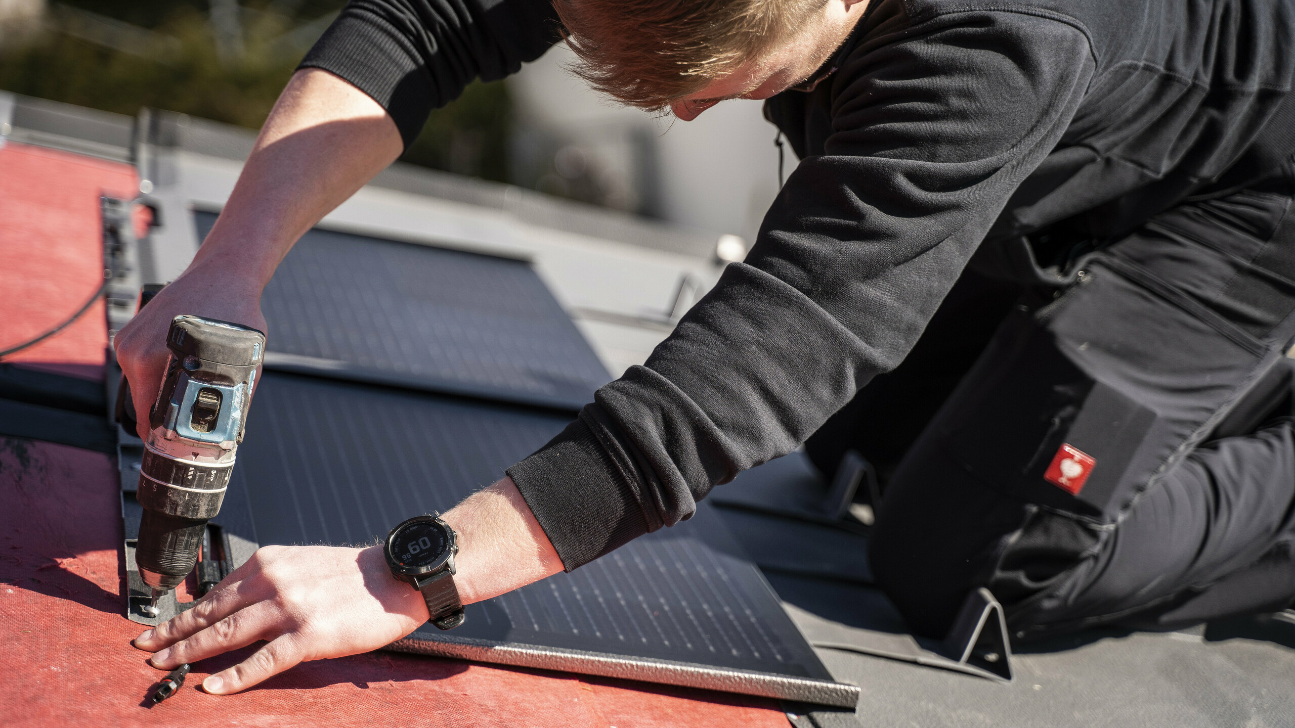 Ein PREFA Mitarbeiter bei der Verlegung der Solardachplatte.